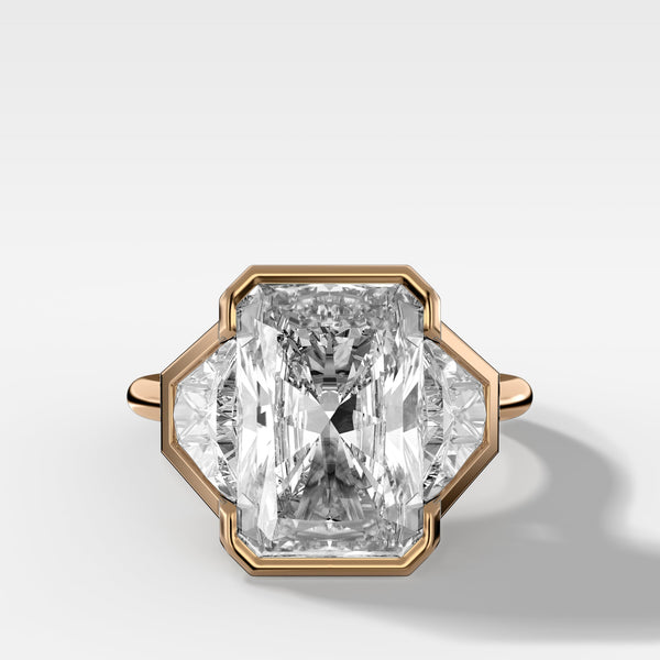 Three Stone Bezel Set Engagement Ring with Trapezoid Side Diamonds and an Elongated Radiant Cut